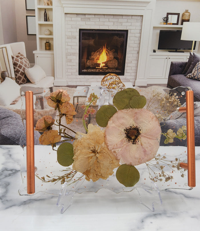 Tall portrait photo of a pressed flower lotus ring dish with soft dried botanicals