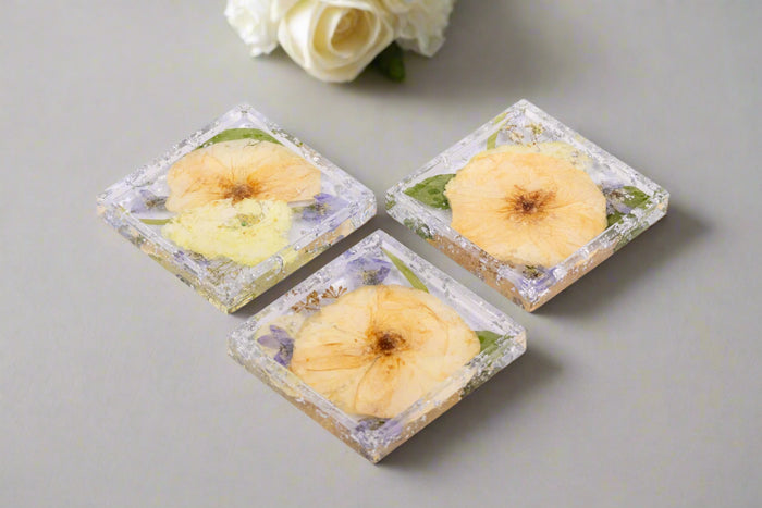 3 pressed flower square trinket trays with white and blue bouquet preservation and silver metallic flake.