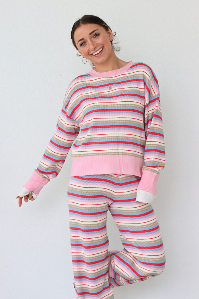 Woman wearing a striped set with pink accents on a white background