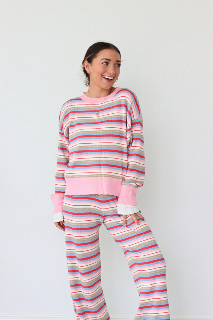 Woman wearing a colorful striped set against a white background
