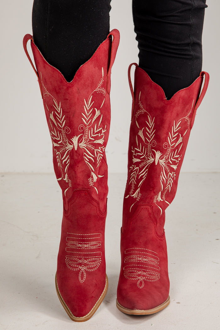 Red cowboy boots with white embroidery on a white background