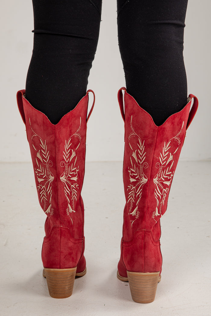 Red cowboy boots with white embroidery on a white background