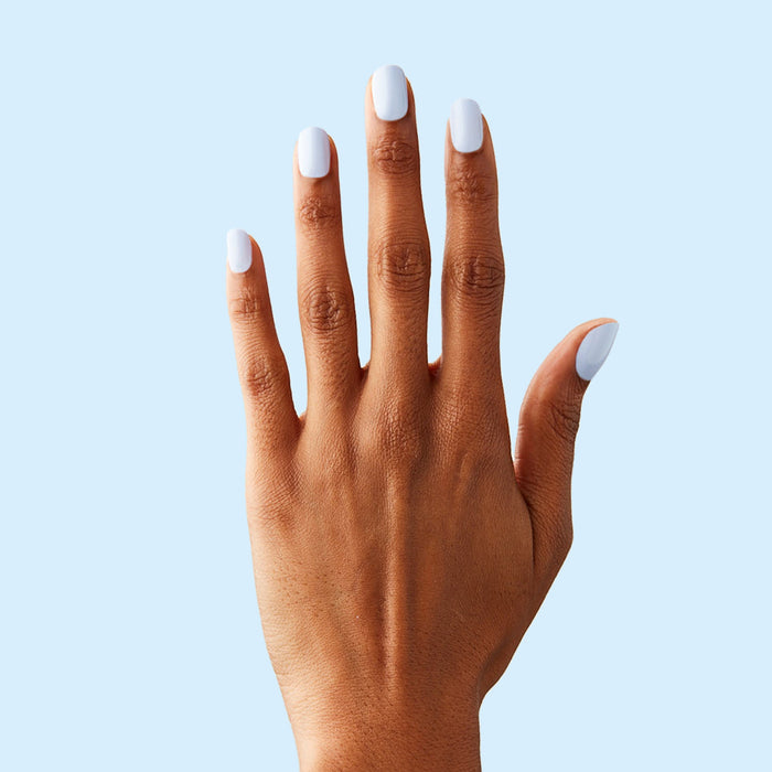 Hand with BP - Press-On | Extra Short | Squoval icy light blue false nails on natural skin tone against light blue background