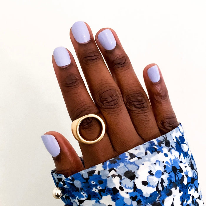 Hand displaying BP - Press-On | Extra Short | Squoval nails in pastel icy light blue on dark skin with blue floral sleeve and gold ring