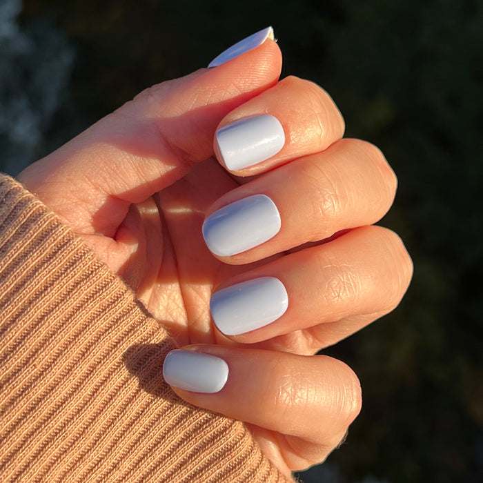 Hand with BP - Press-On | Extra Short | Squoval false nails in icy light blue on natural skin tone in sunlight