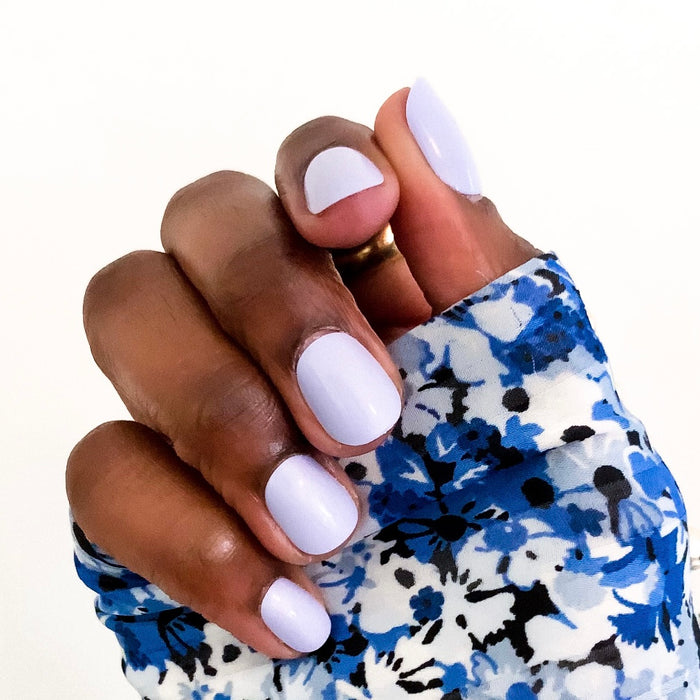 Hand with BP - Press-On | Extra Short | Squoval false nails in pastel icy light blue on medium-dark skin tone against white background
