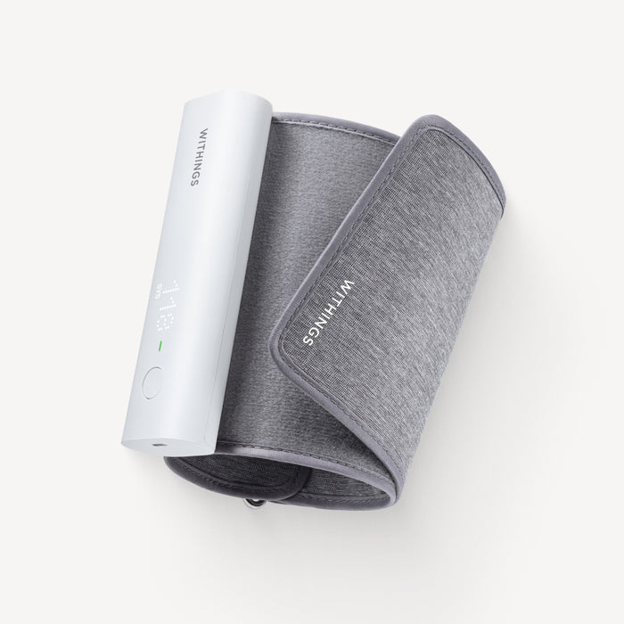 Withings BPM Connect — Connected blood pressure monitor — Top-down view, rolled grey cuff with white monitor module, plain light background — top-down, cuff, white module, compact