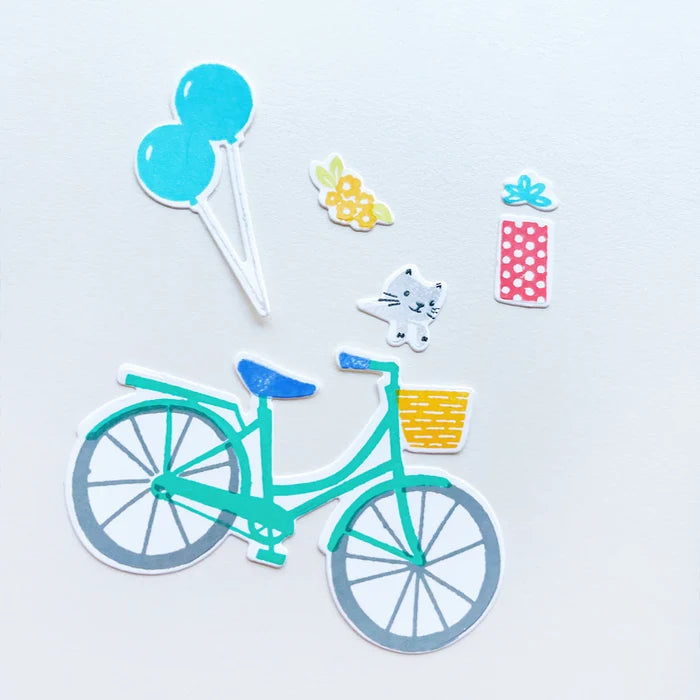 Catherine Pooler - Stamp &amp; Die Set - Pedaling By. Featuring a birthday bike with tons of fun decorations. Decorate with the gifts, balloons and bunting. There's also a basket that can be filled with flowers or a kitty to take along or the ride! Available at Embellish Away located in Bowmanville Ontario Canada.
