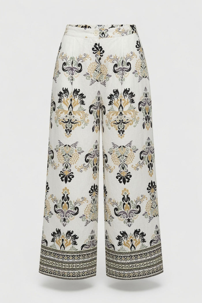 White wide-leg cropped pants with a black and beige baroque-style damask pattern and a decorative border on the hems, shown against a light gray background.