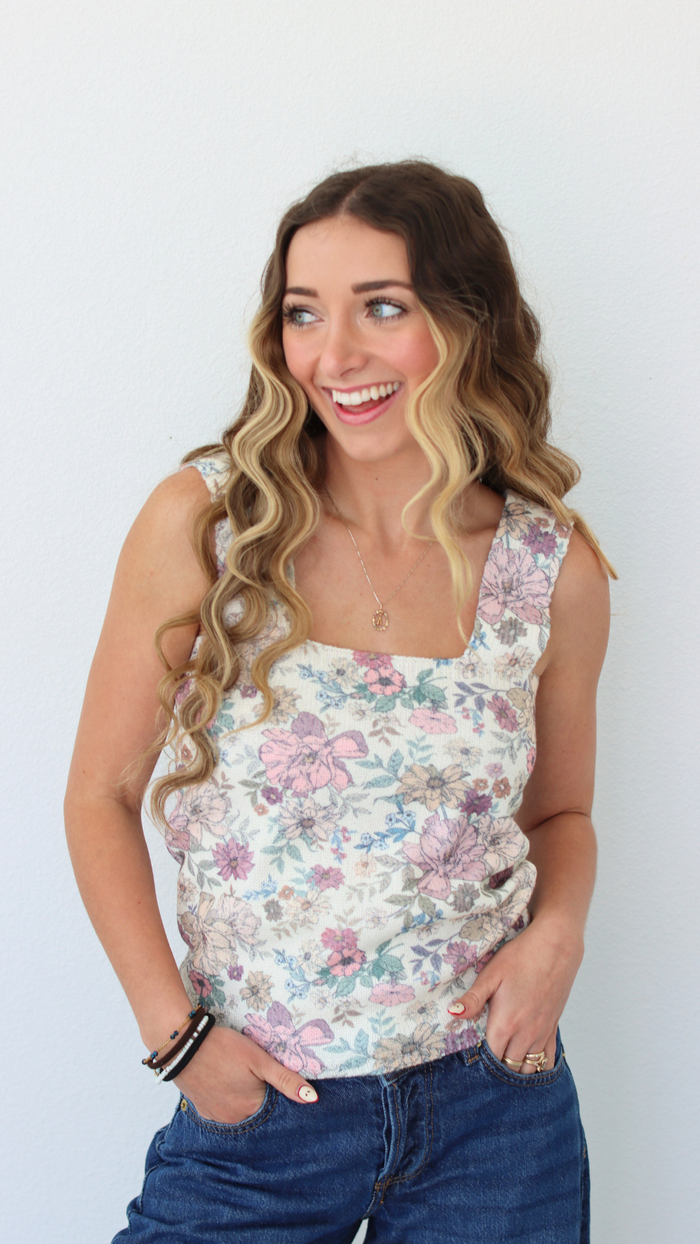 woman wearing a floral tank top with a white background