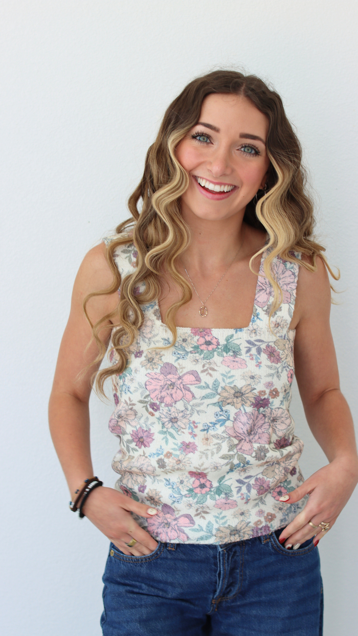 woman wearing a floral tank top with a white background