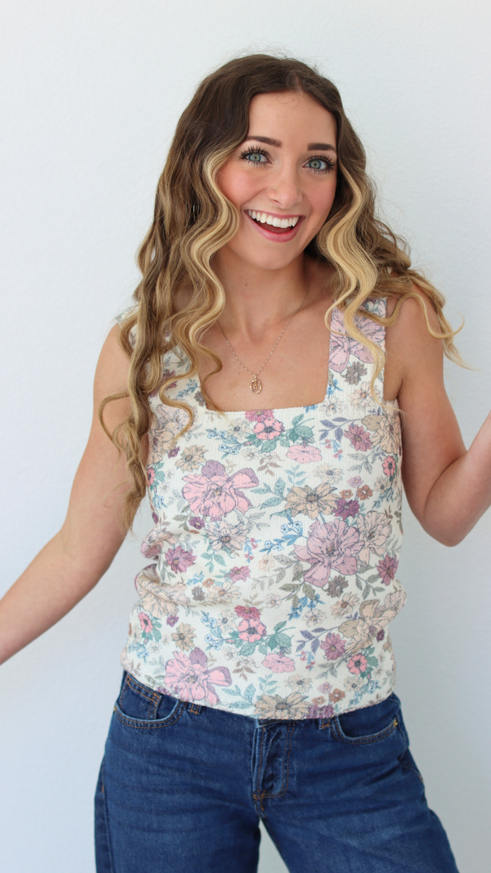 woman wearing a floral tank top with a white background