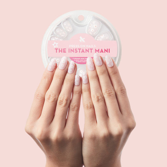 Flower Shower - Press-On | Short | Round showing hands with short round nails in soft ombré with white daisy flower designs