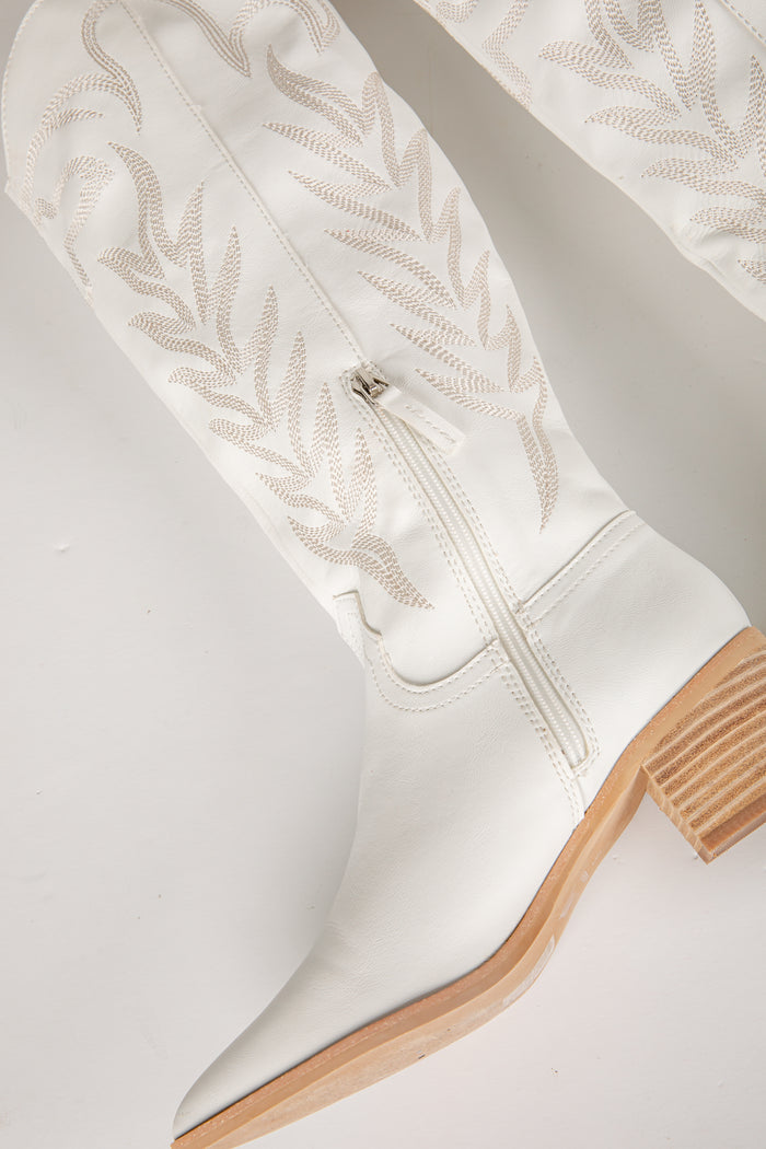 White knee-high boot with wooden sole on a light gray background