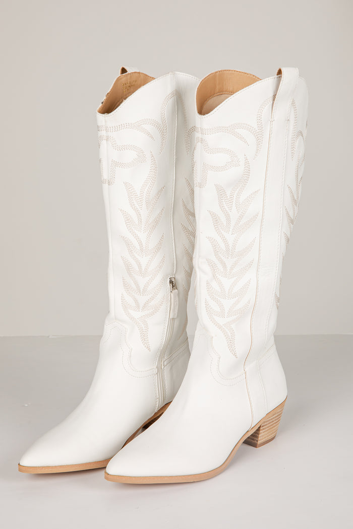 White quilted knee-high boots on a light gray background