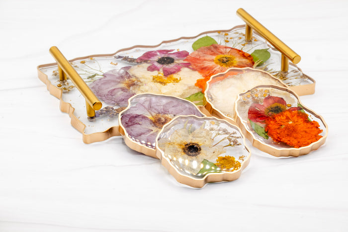 Landscape photo of a pressed flower acrylic tray with soft dried roses on a white surface