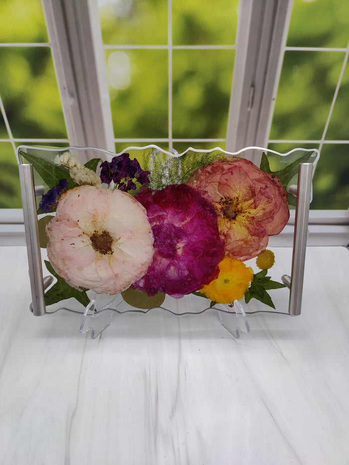 Tall portrait photo of an early pressed flower resin block with vibrant tropical dried blooms