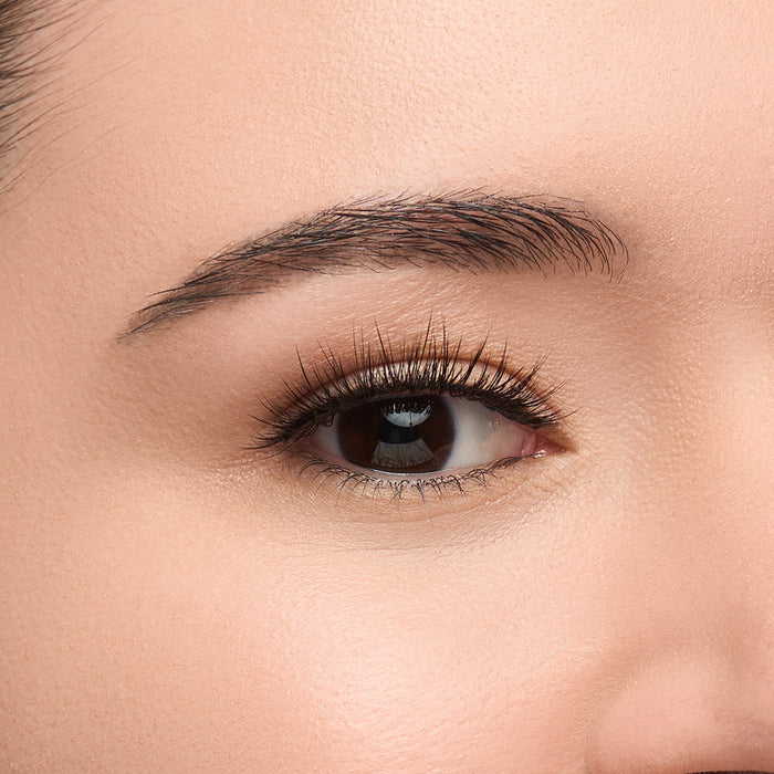 Hazel Mini round false lash with medium volume, short length, and feathery fibers shown on an eye.