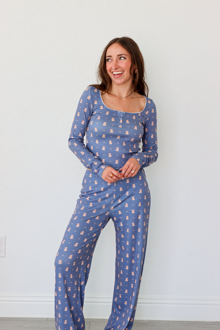 Woman wearing a blue patterned pajama set against a white background