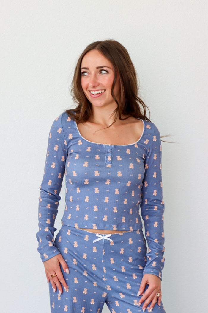 Woman wearing a blue pajama set with bear pattern against a white background