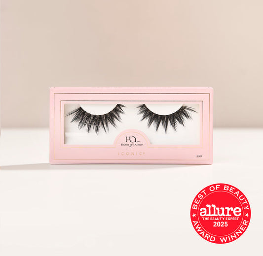 Iconic false lashes in pink packaging set against a pale beige backdrop.