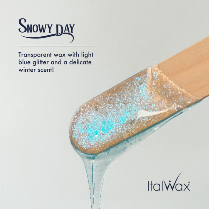 W501 Italwax Snowy Day Film Wax | Transparent wax with light blue glitter on a wooden spatula, branded as Italwax.