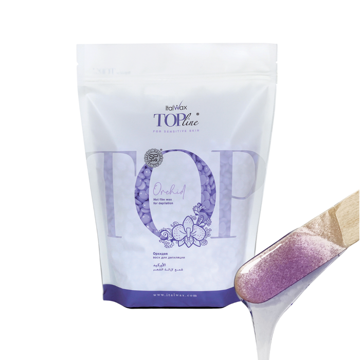 W370 Italwax 1kg Top Line Synthetic Orchid Film Wax | A bag of jelly purple Orchid film wax in a branded Italwax plastic bag with jelly purple wax beads showing, and in the foreground a wooden spatula with jelly purple wax dripping
