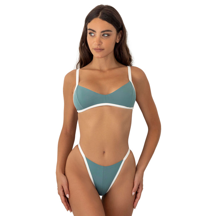 Woman wearing a teal and white bikini on a white background