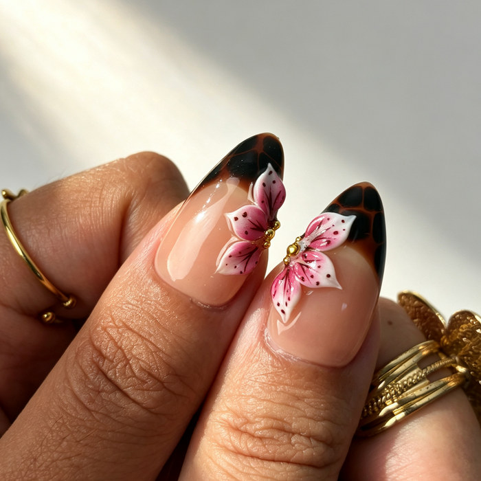Close‑up handmade press‑on nails, pink sculpted butterfly gold‑bead pearl‑chain manicure