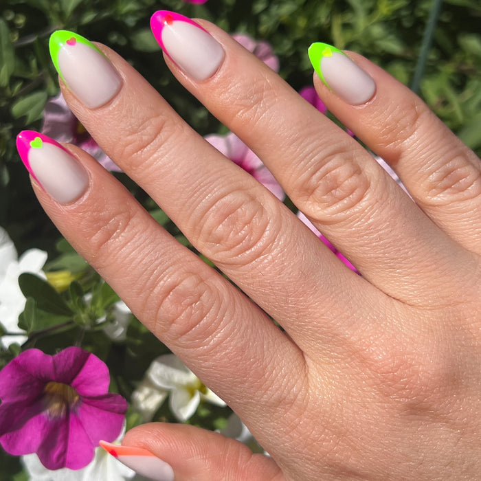 Neon Heart French | Almond | Medium press-on nails with neutral base, neon tips, and small neon heart designs for a bright mani