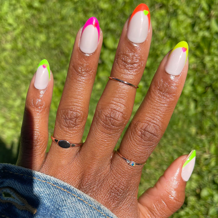 Neon Heart French | Almond | Medium press-on nails with neutral base, neon tips, and small heart details for a bright mani