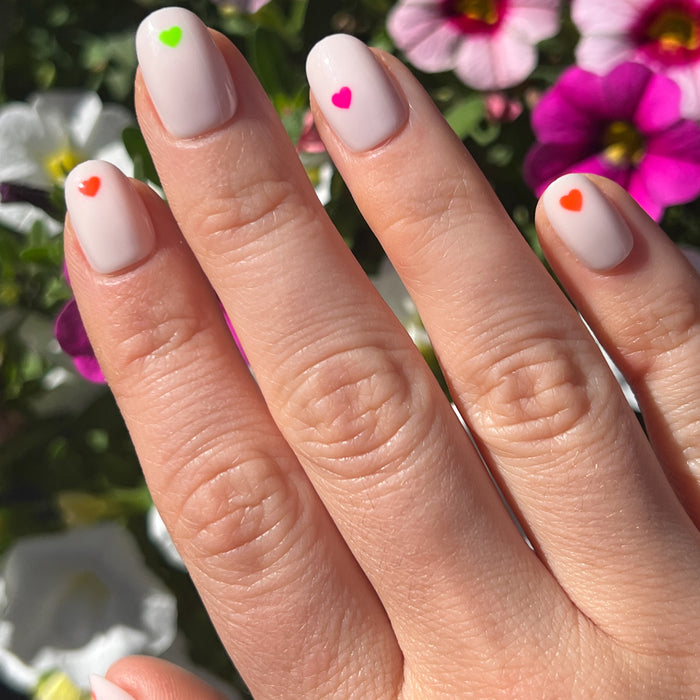 Neon Hearts | Round | Extra Short press-on nails with neutral base and colorful neon hearts for a bright at-home mani