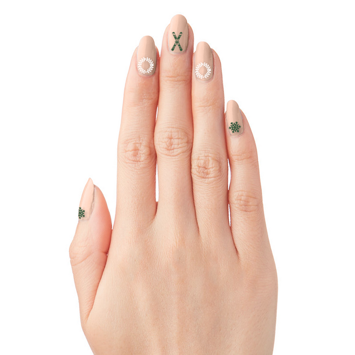 Hand with nails featuring winter-themed designs using O&J Cozy Lodge Nail Art Stickers for festive manicures