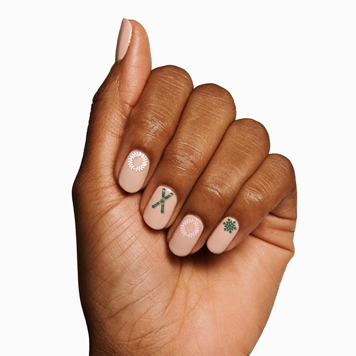 Hand with neutral polish featuring delicate winter motifs using O&J Cozy Lodge Nail Art Stickers for festive mani designs
