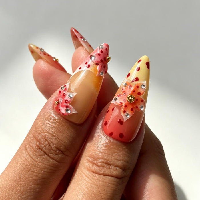 Bright warm‑tone 3D floral stiletto fake nails close‑up