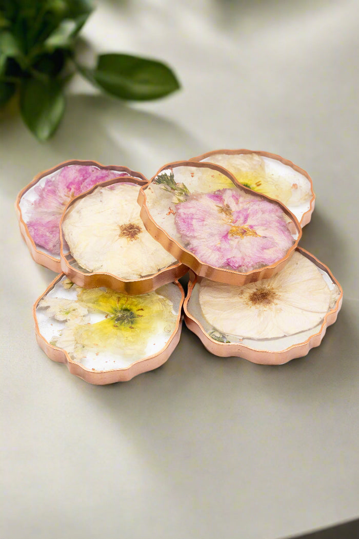 Stack of pressed flower geode coasters with gold edges