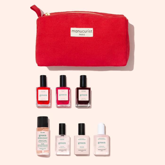 The Manucurist Starter Kit features a red pouch with seven nail care products—including plant-based polish in four colors, nail polish remover, clear polish, and a white bottle—displayed on a light pink background.