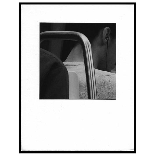 black and white photograph of ear bud in ear
