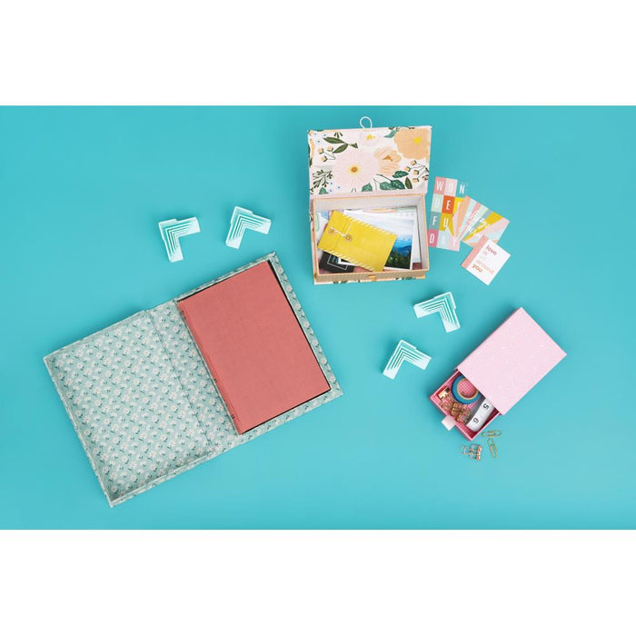 We R Memory - Corner Guides - 4/Pkg. Great for boxes, book covers, dioramas, and more! Holds corners tightly while adhesive sets. Works with 3mm, 2mm, 1.5mm, and 1mm wide chipboard. Imported. Available at Embellish Away located in Bowmanville Ontario Canada.